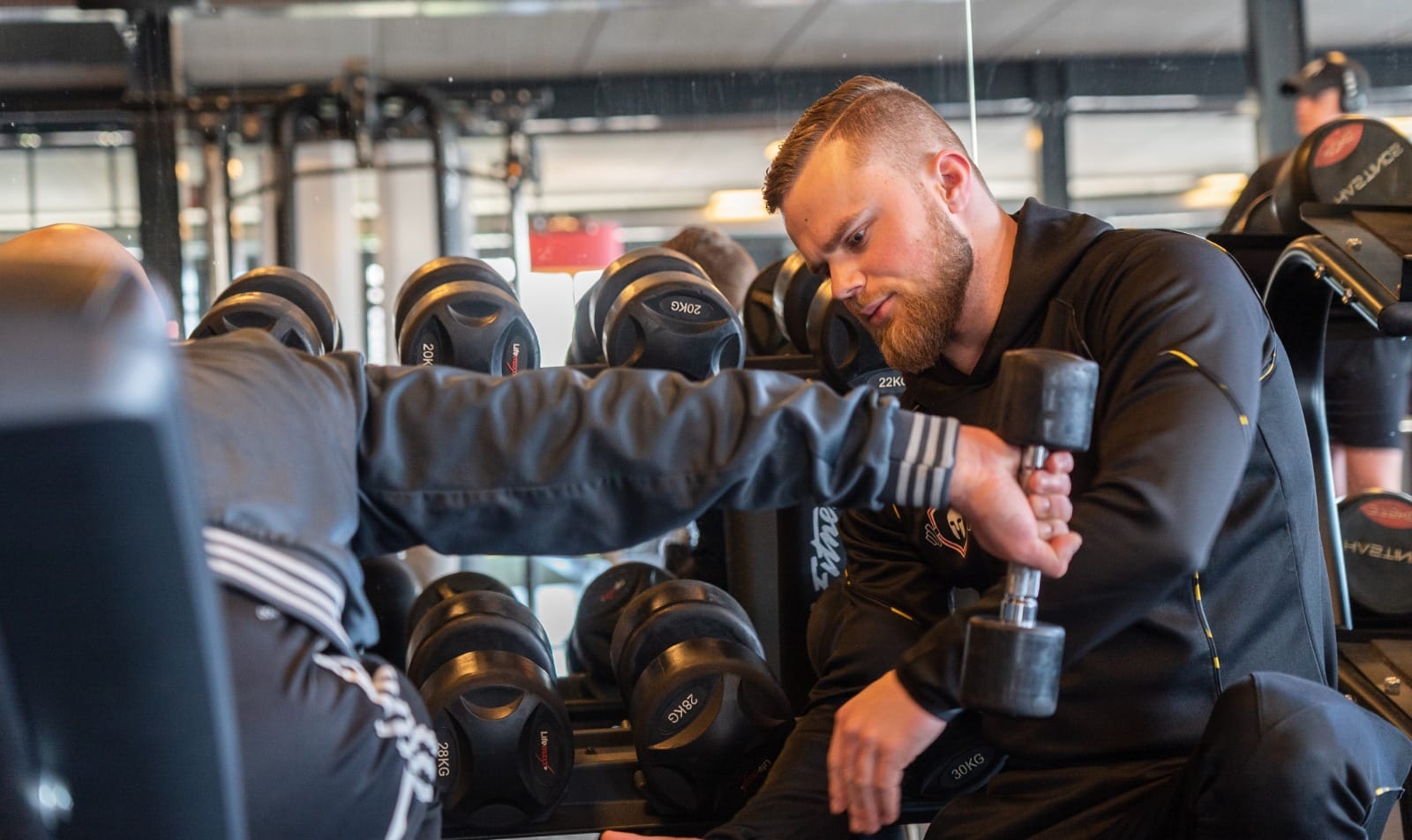 Begeleiding bij een kabeloefening in de sportschool
